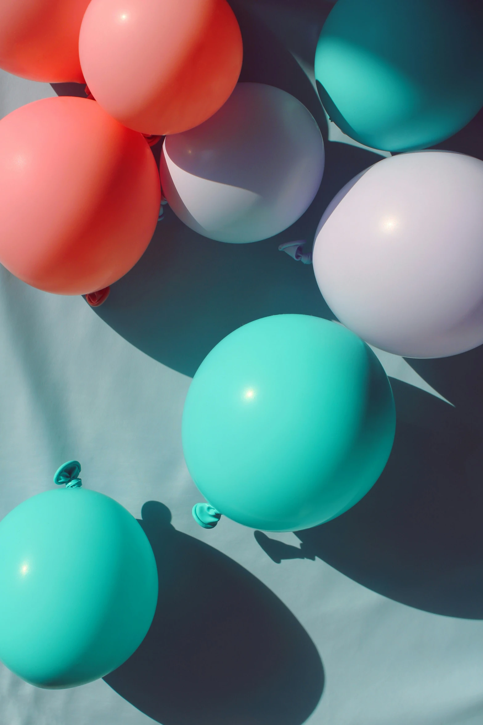 a group of balloons floating on a blue and white background