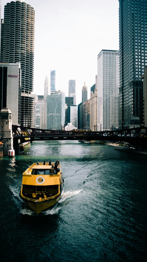 a large yellow boat traveling through a large city