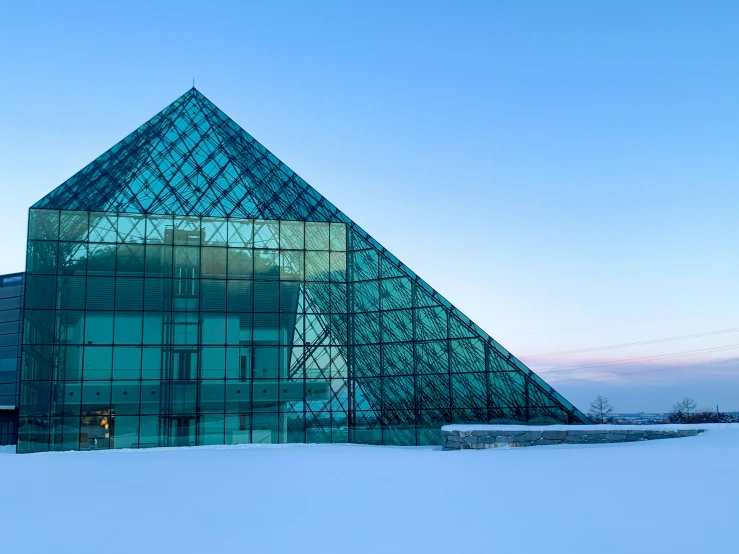 the outside of a large glass building in winter