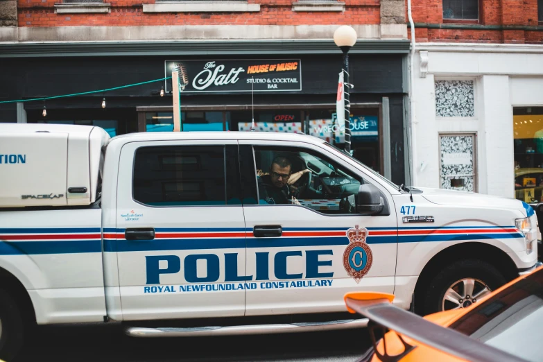 a police truck is parked in front of a business