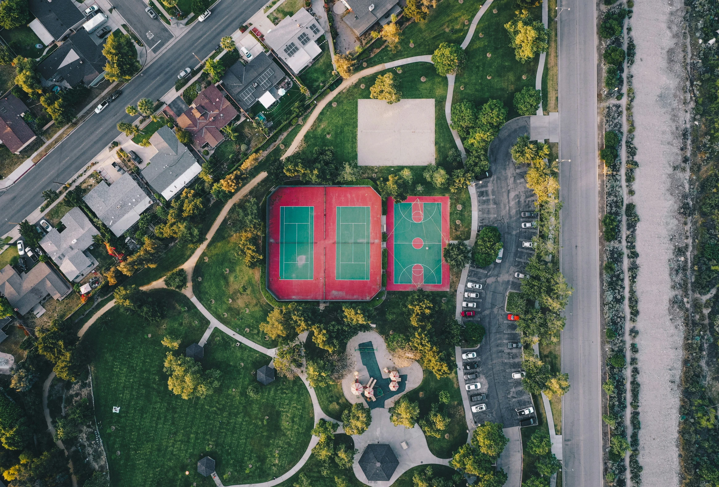 an aerial s of a park with a tennis court