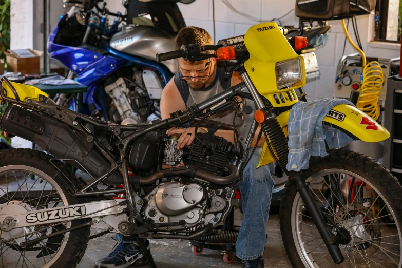 a man working on a motorcycle engine inside of a garage