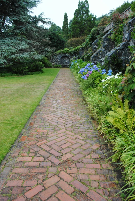 a brick path leads up to a rock wall