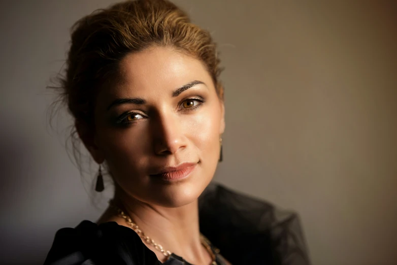 a woman posing with black top and necklace