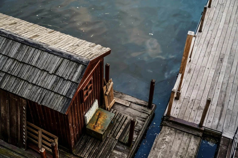 a small pier with old red wooden shacks