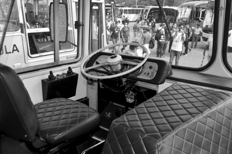 the front seats of a bus in a crowded parking lot