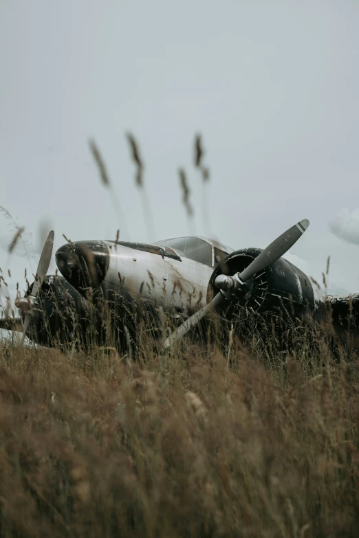 an old airplane with a missing wing sits in a field