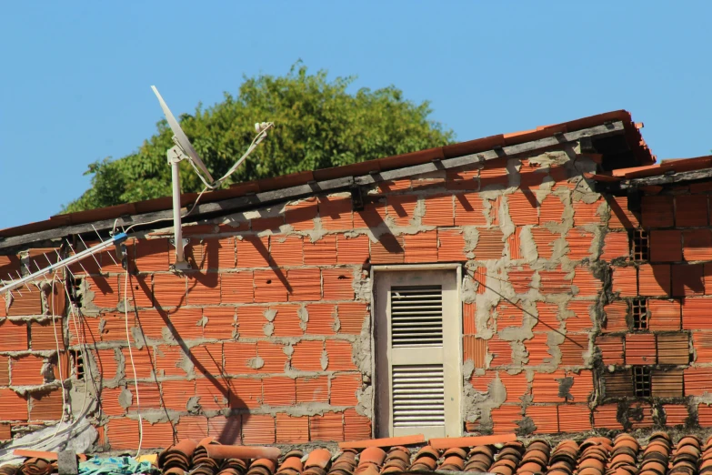 a red brick wall and brown metal wire on top of a building