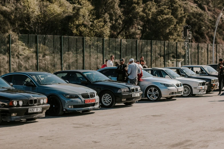 there are many cars parked in line by a fence