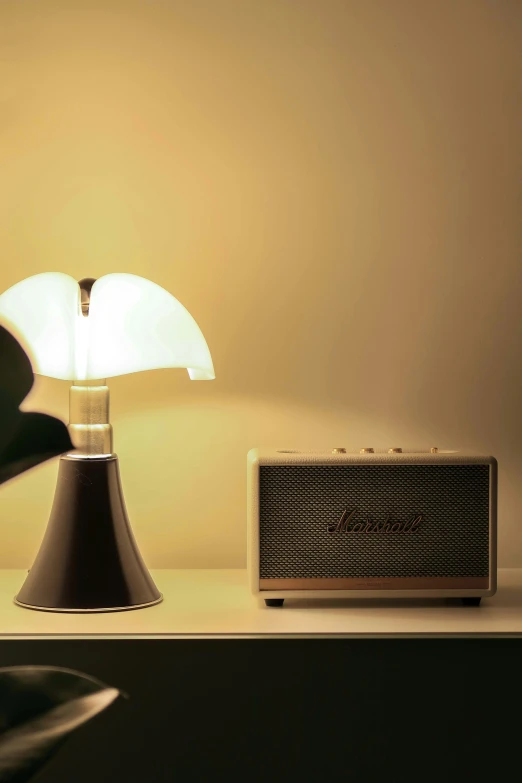 a table lamp, a radio, and a speaker on a table