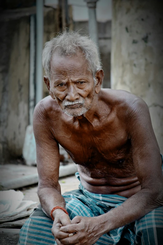 a man with white hair and  sitting down