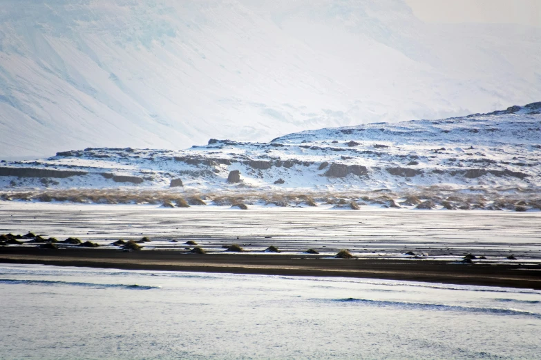 a snowy hill side with hills and snow in the background