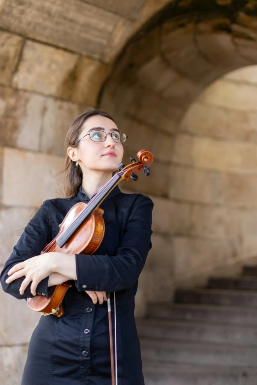 a woman playing a violin and posing for a po