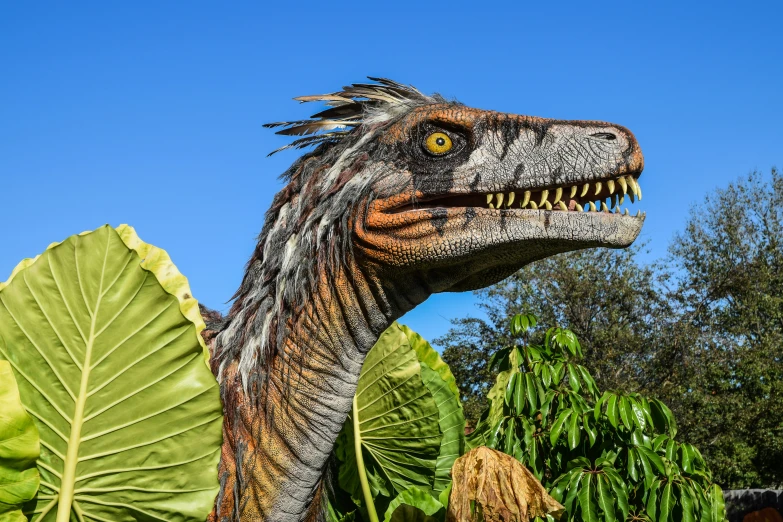 dinosaur sculptures in a garden next to trees and plants