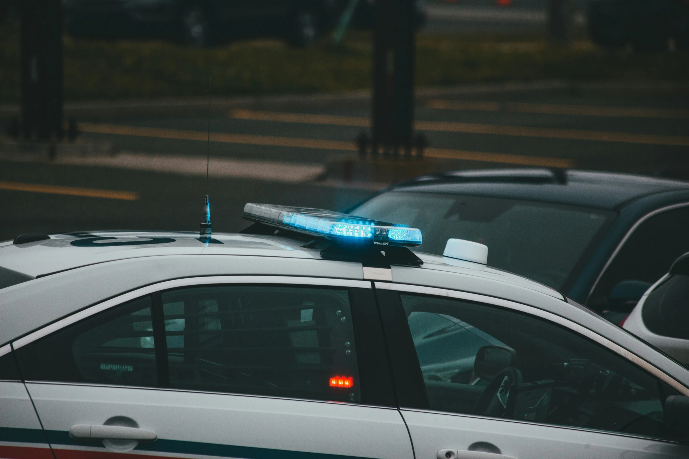 the car is parked near a curb on a rainy day