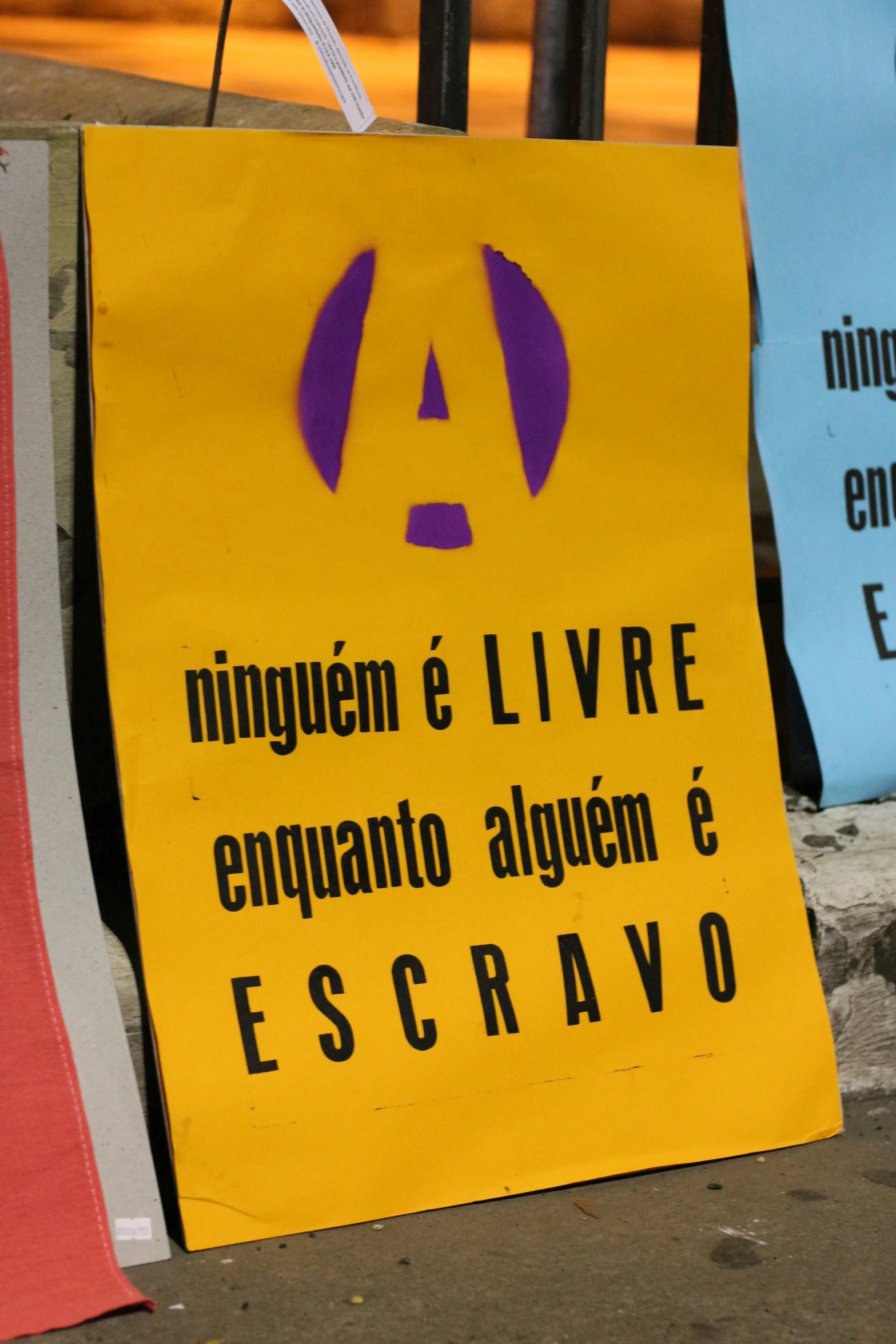 a yellow sign in spanish hangs on a rope