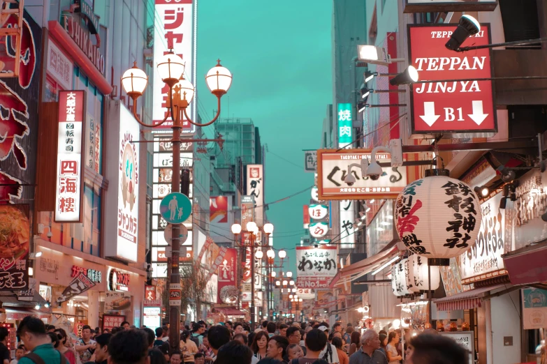 an asian street with pedestrians and businesses and neon signs on the buildings