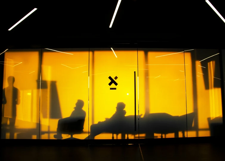 a shadow on the glass of a door and people sitting at tables