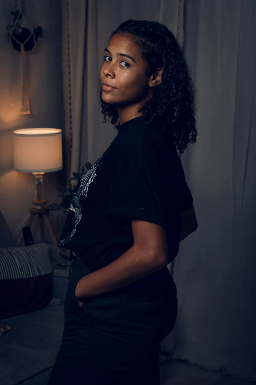 a woman standing by the window in a dark room