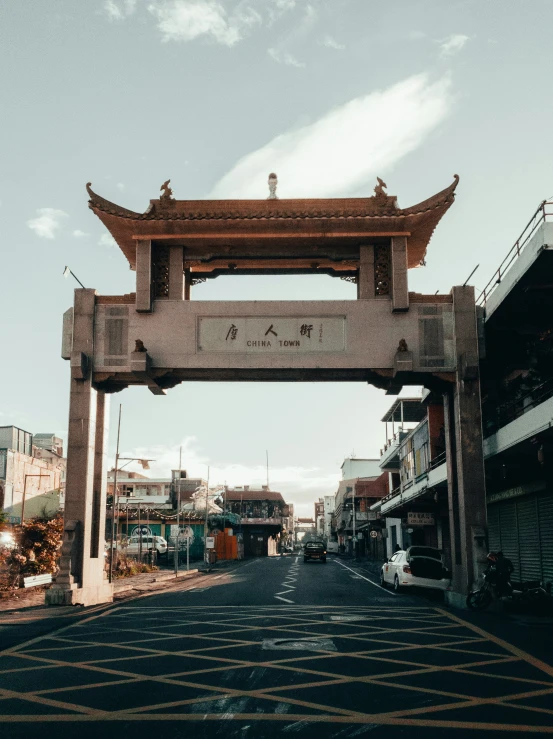 a road lined with shops with an archway above