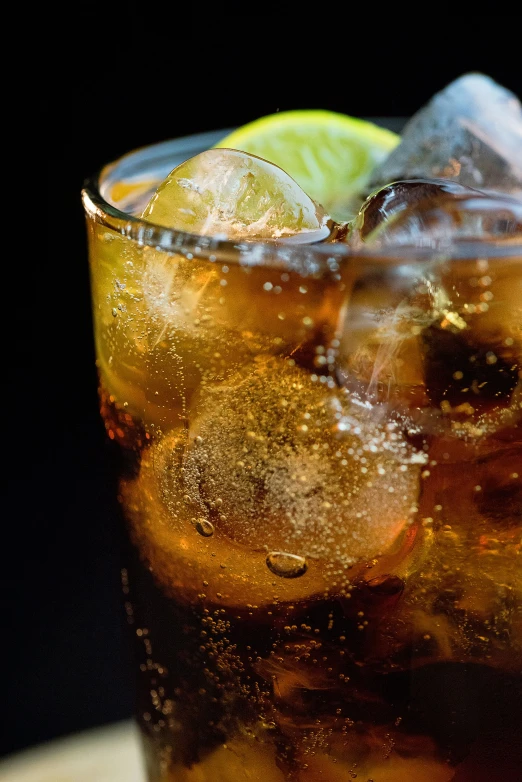 soda, ice and lime in glass on wood board