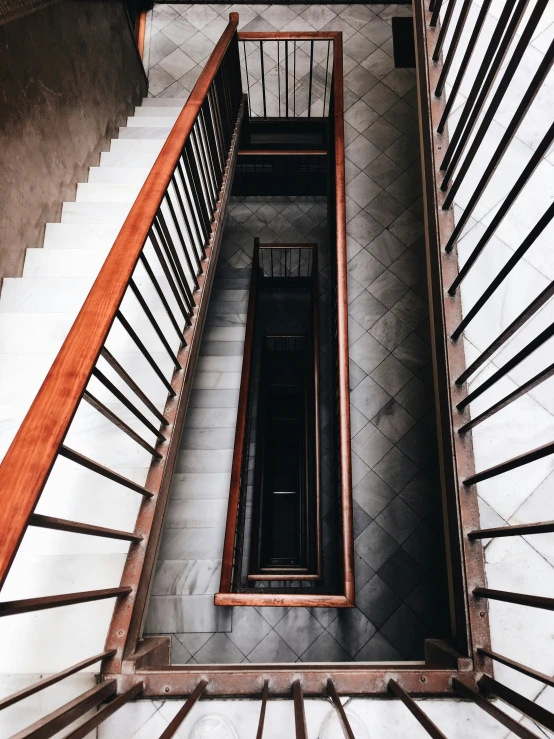 a close up of a stairwell with wooden rails