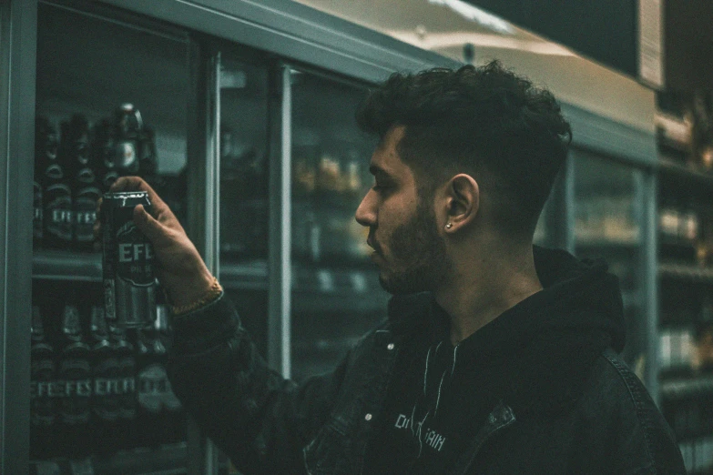 a man with a camera looking through a wine case