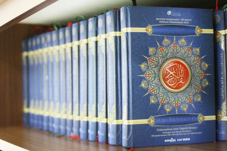 several blue books in a row with a arabic script on the covers