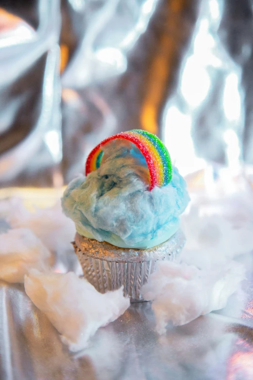 a rainbow colored cupcake that has been frosted