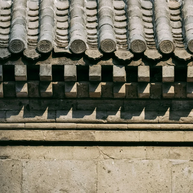 an oriental style roof has long row of stone fan vents