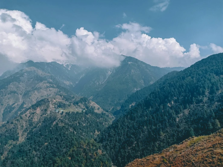 there are many hills with trees below on the other side