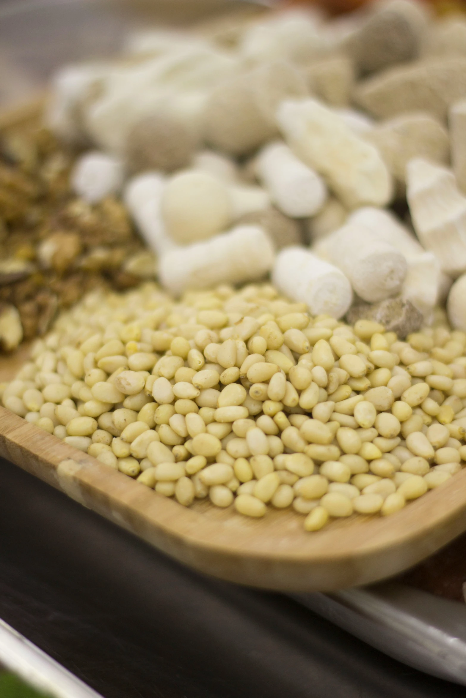 a wooden spoon with beans and mushrooms on it