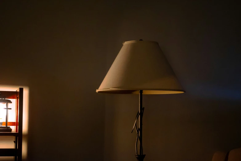 a room with a table and lamp lit by an ironing board