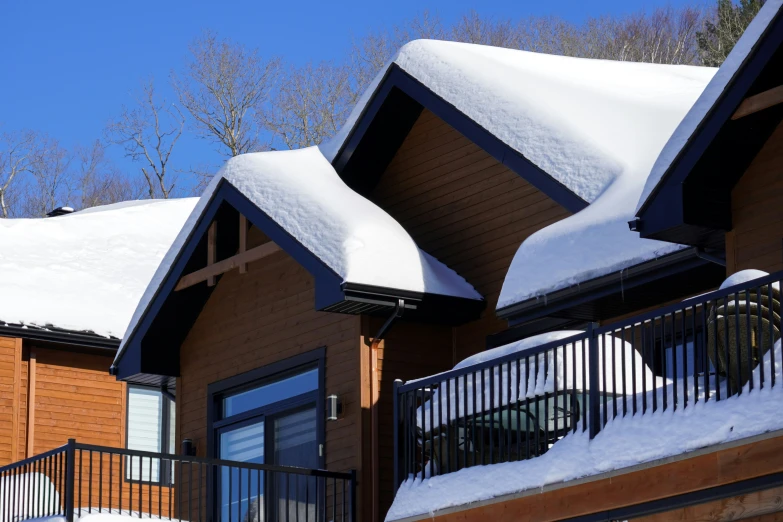 a house covered in snow with a balcony and railing