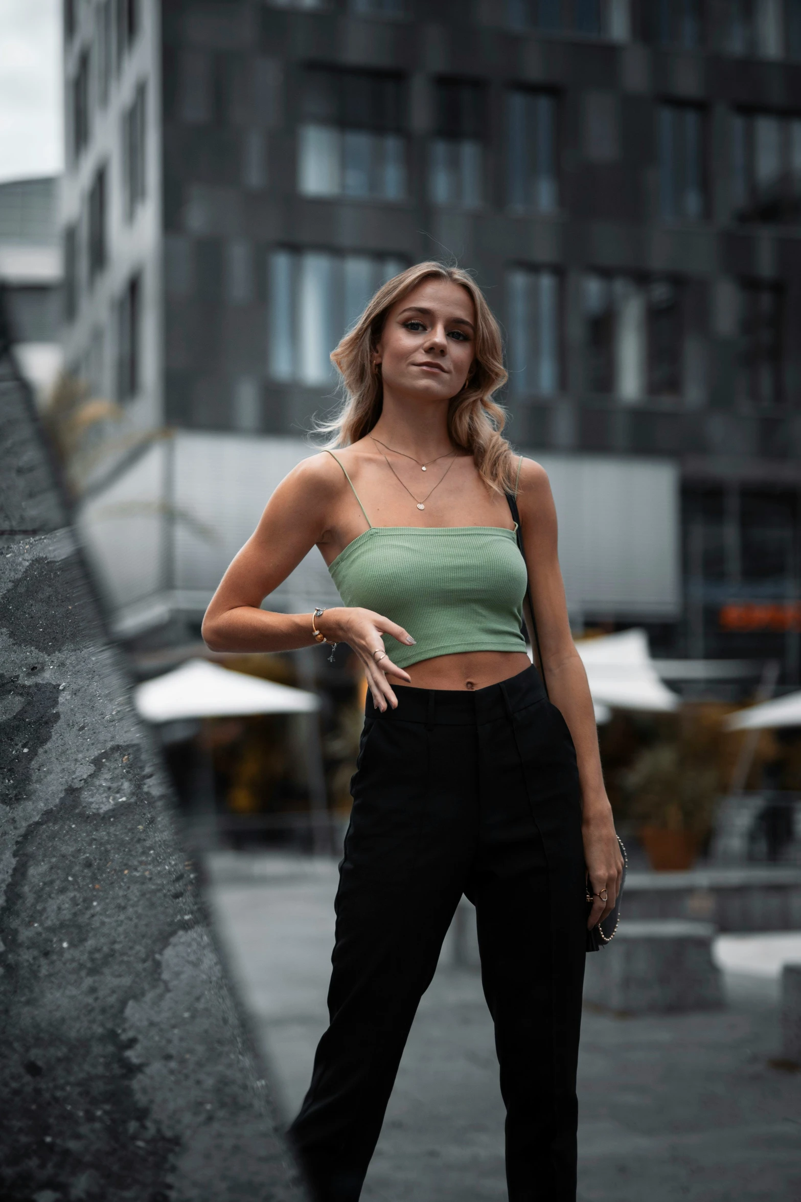 a woman standing on a ledge with her hand on her hip