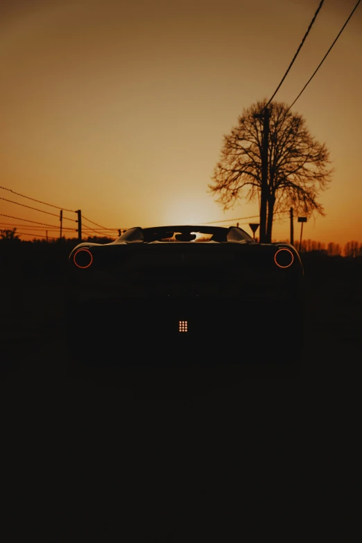 the silhouette of an old car with a tree