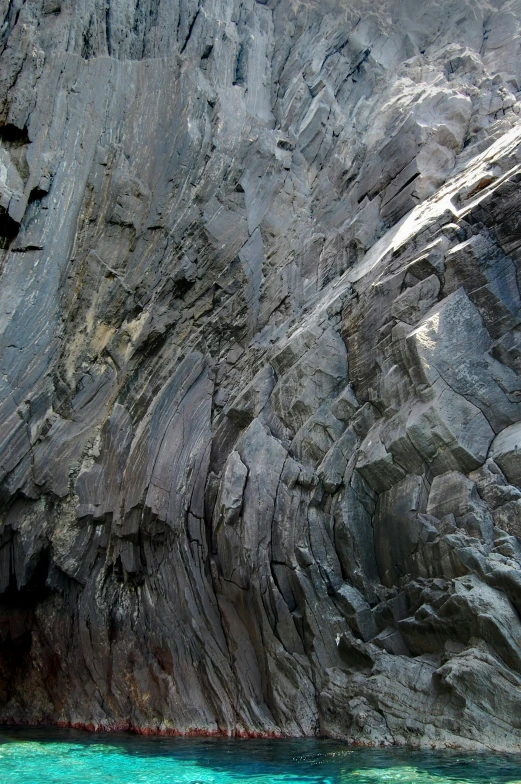 a large rock formation with water at the bottom