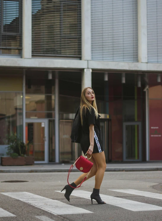 there is a woman walking on the street with a purse