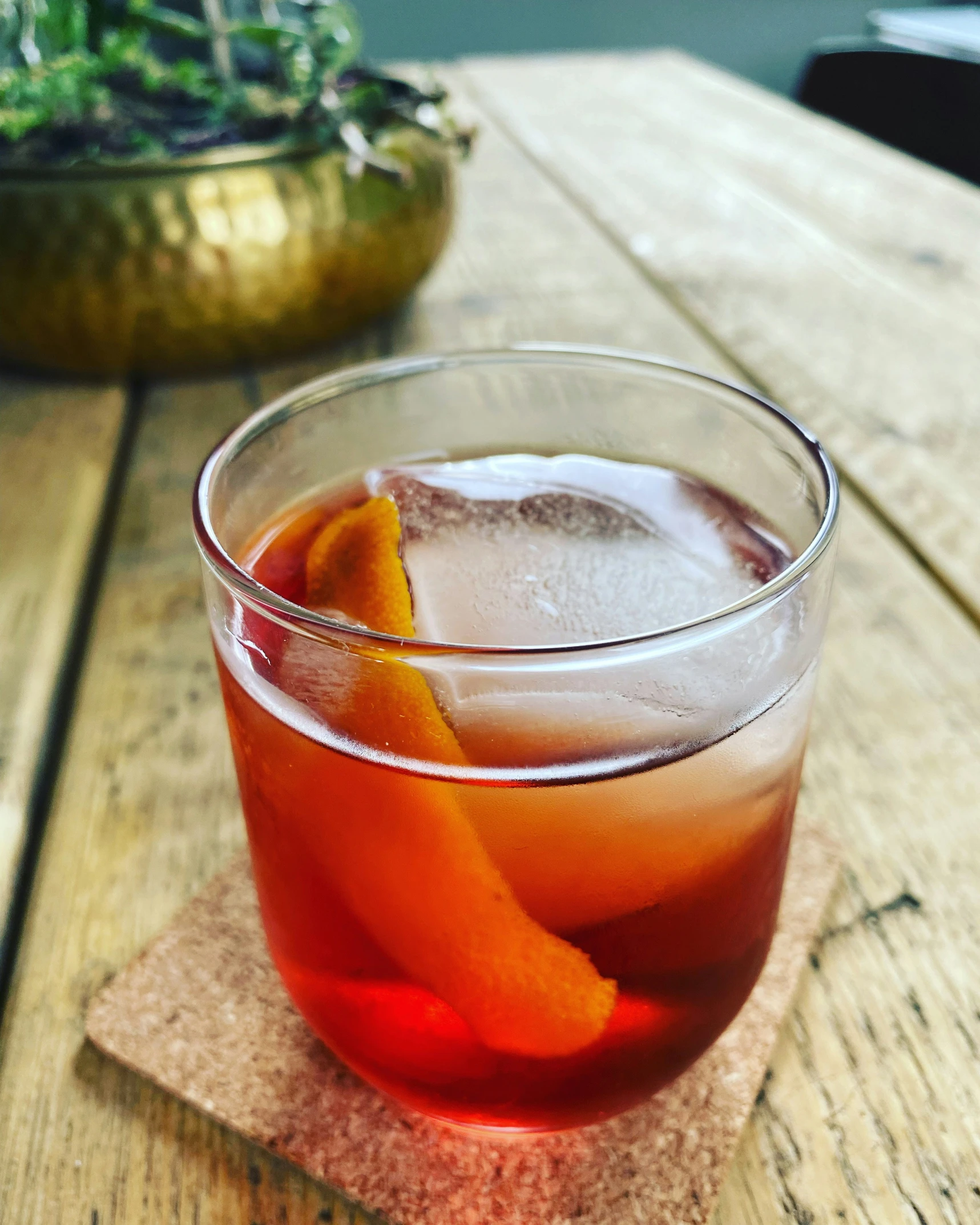 a glass with an orange wedge and garnish on the side