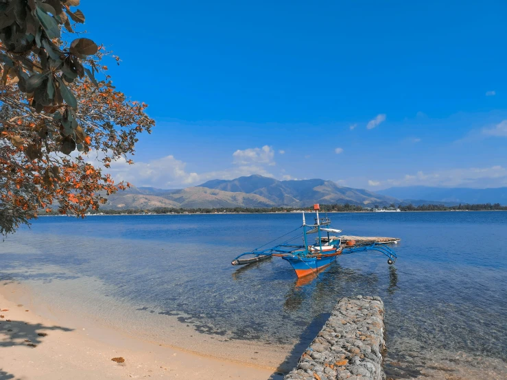 a boat is docked at the shore line by the water