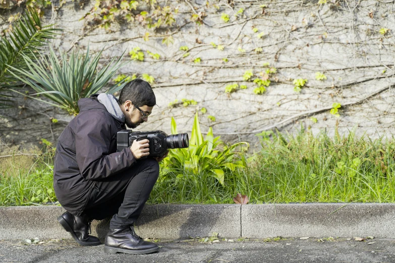 a man is squatted next to the grass