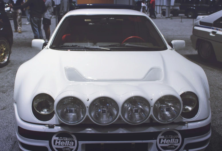 the front end of a white car on display