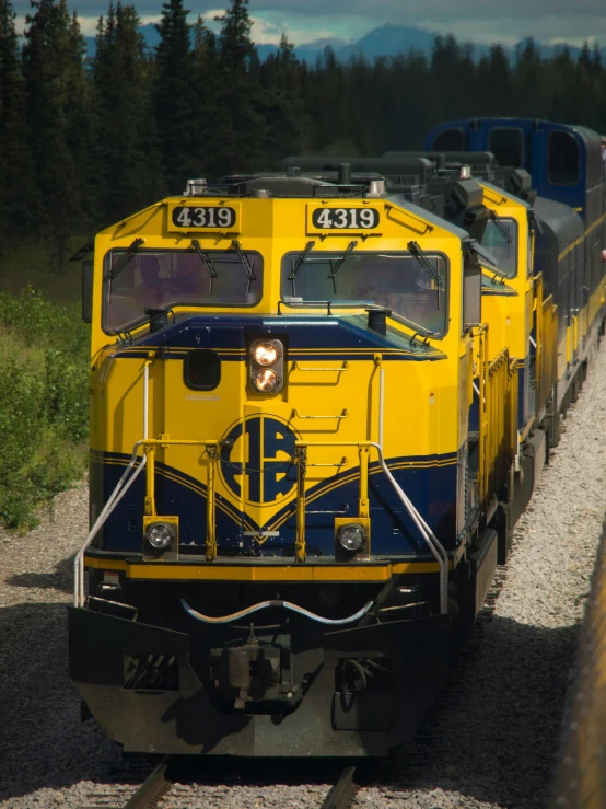 a yellow and black train traveling down the railroad track