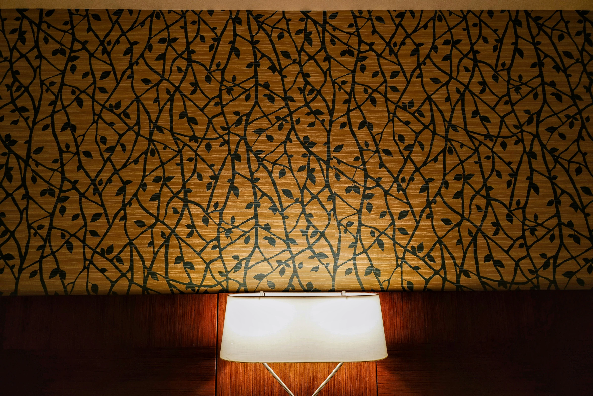 the lamp is next to the wall that has a pattern on it
