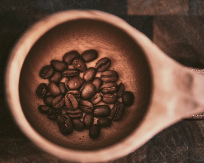 a cup of coffee that has a small amount of coffee beans in it