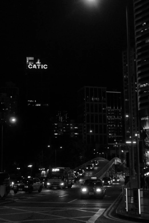 traffic at night with a lit up sign in the sky