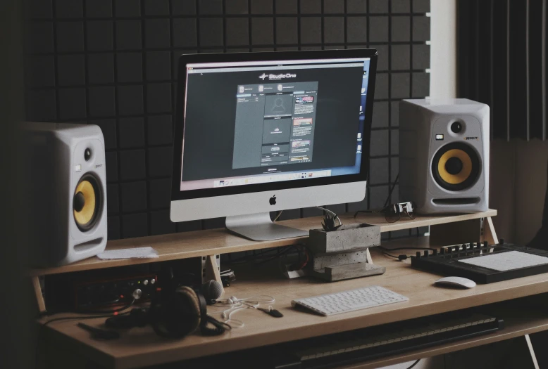 a computer monitor with audio speakers sitting on top of it