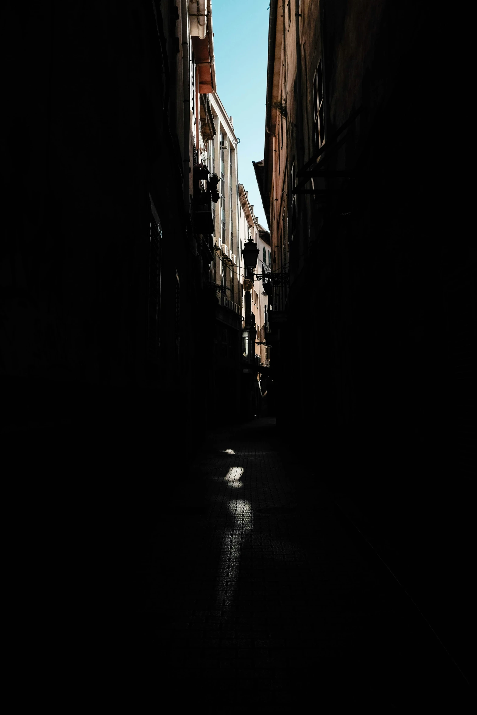 light shining on dark alley way with shadows