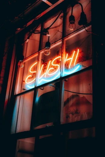 an neon sign on a shop window shows the name bish