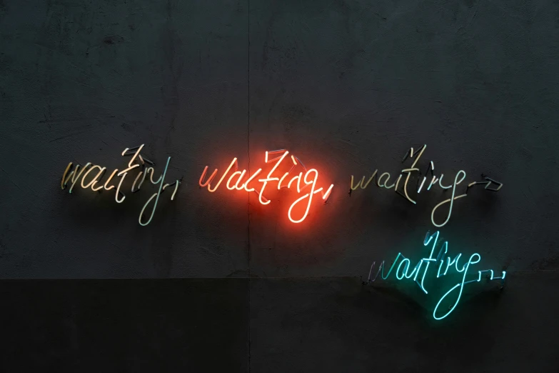 three neon signs in front of a wall